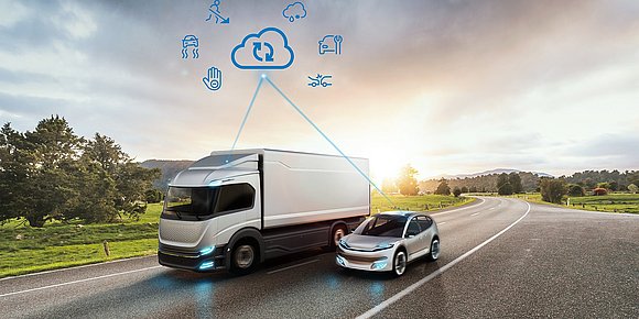 Lastwagen und Auto fahren nebeneinander, darüber schwebt digitale Cloud